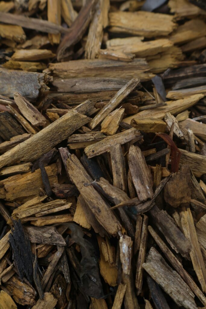 Nahaufnahme von Holzhäcksel und Rindenstücken – Material zum Beete mulchen unter Gehölzen
